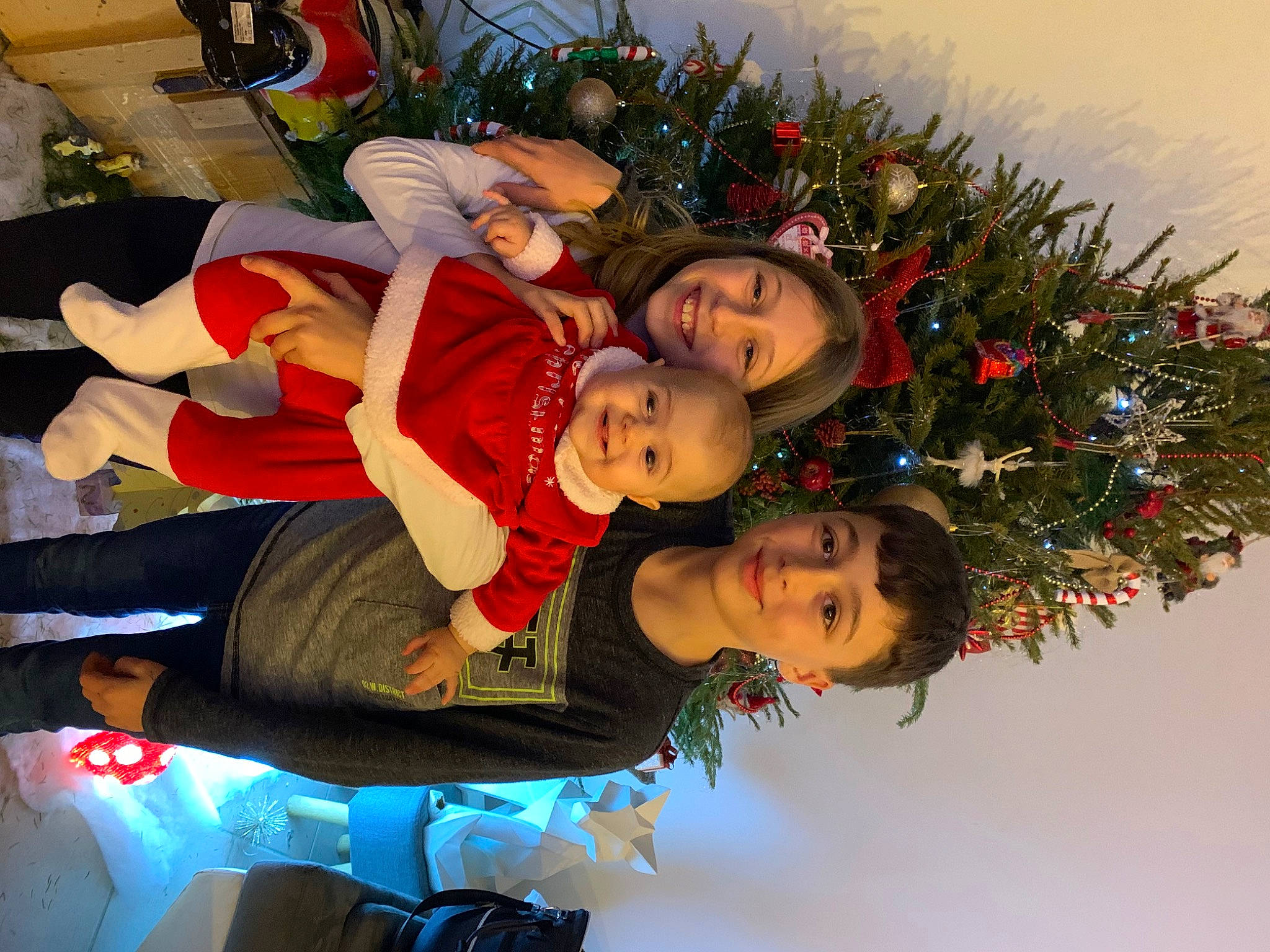 Love participe au concours pour gagner de l'argent avec cette photo : child, christmas, christmas_decoration, christmas_eve, christmas_ornament, christmas_tree, event, fun, happy, hat, holiday, holiday_ornament, human_body, joy, lap, ornament, person, smile, toddler, tradition