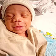 Emil is registered to the contest to win money with this photo: baby, bed, blanket, child, clothing, cozy, cute, face, hat, indoor, infant, newborn, person, portrait, resting, sleepy, smile, soft, toddler, warm