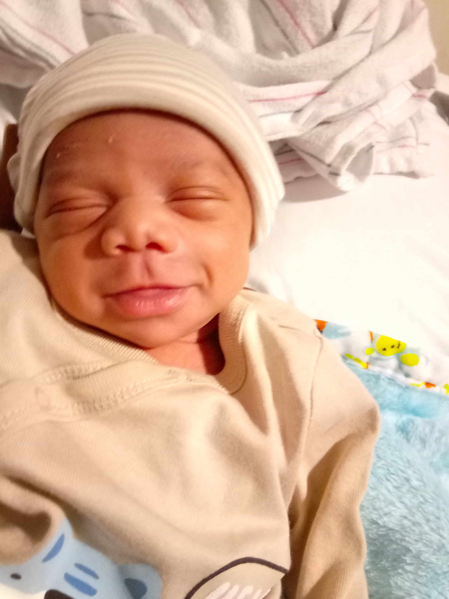 Emil is registered to the contest to win money with this photo: baby, bed, blanket, child, clothing, cozy, cute, face, hat, indoor, infant, newborn, person, portrait, resting, sleepy, smile, soft, toddler, warm