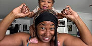 Sareya is registered to the contest to win money with this photo: baby, child, woman, smiling, happy, indoor, home, portrait, holding_hands, shoulder_ride, person, furniture, ceiling_fan, braids, headwear, floor_tiles, casual_clothing, joy, family, playful