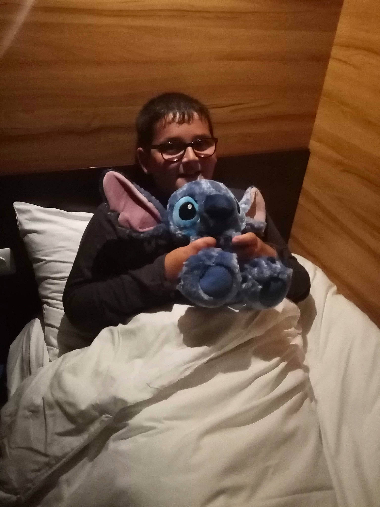 Matheo participe au concours pour gagner de l'argent avec cette photo : arm, audio_equipment, bed, camera, cameras_optics, comfort, companion_dog, couch, fur, gadget, glasses, human_body, linens, person, plush, room, selfie, sitting, stuffed_toy, toy