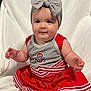Kora is registered to the contest to win money with this photo: baby, child, cheerleader_outfit, headband, bow, red_dress, gray_top, sitting, barefoot, cute, infant, portrait, smiling, indoor, soft_blanket, happy, person, toddler, cheer, sportswear