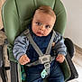 baby, child, high_chair, denim_overalls, pacifier, toy, blue_eyes, grey_sweater, straps, indoor, floor, wooden_floor, curious_expression, seated, infant, cute, clothing, person, face, hand