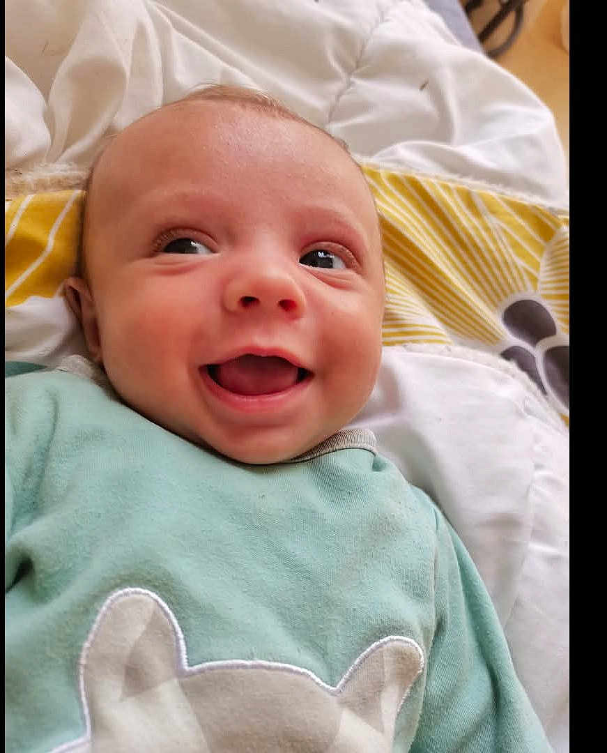 Kenny a rejoint le concours — aidez-le/la à gagner de superbes lots ! baby, smiling, infant, face, eyes, mouth, clothing, blanket, lying_down, happy, cute, child, portrait, indoors, skin, head, expression, young, cozy, fabric