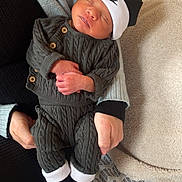 Ibrahim a rejoint le concours — aidez-le/la à gagner de superbes lots ! baby, blanket, cable_knit, comfort, cozy, cute, hands, holding, indoor, infant, knitted_clothing, newborn, nike_booties, nike_hat, patterned_bedspread, person, resting, sleeping, soft_texture, warm