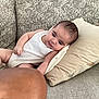 Isaac a rejoint le concours — aidez-le/la à gagner de superbes lots ! baby, infant, couch, pillow, white_clothing, indoor, person, face, head, skin, relaxing, curious, arm, furniture, textile, home, comfort, casual, closeup, human