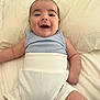 baby, smiling, infant, bed, clothing, blue_top, white_bottoms, happy, cute, lying_down, skin, head, arms, legs, indoors, soft_surface, face, portrait, child, toddler