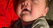Liam is registered to the contest to win money with this photo: arm, baby, blanket, cheek, closeup, couch, cute, indoor, infant, mitten, nap, newborn, onesie, pillow, portrait, relaxed, sleeping, smile, soft_lighting, star_pattern