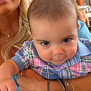Easton Hanrahn is registered to the contest to win money with this photo: baby, child, person, face, plaid_shirt, arm, bracelet, hand, adult, indoor, blonde_hair, portrait, clothing, expression, cute, holding, closeup, skin, casual, smile
