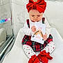 Cléa participe au concours pour gagner de l'argent avec cette photo : baby, child, red_bow, headband, plaid_dress, white_blanket, socks, red_socks, card, marble_wall, glass_panel, indoor, cute, infant, toddler, sitting, holding, looking_down, patterned_tights, playful