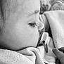 baby, pacifier, sleeping, close_up, profile, blanket, child, face, eyelashes, monochrome, black_and_white, peaceful, infant, hand, soft_texture, cozy, portrait, resting, newborn, toddler