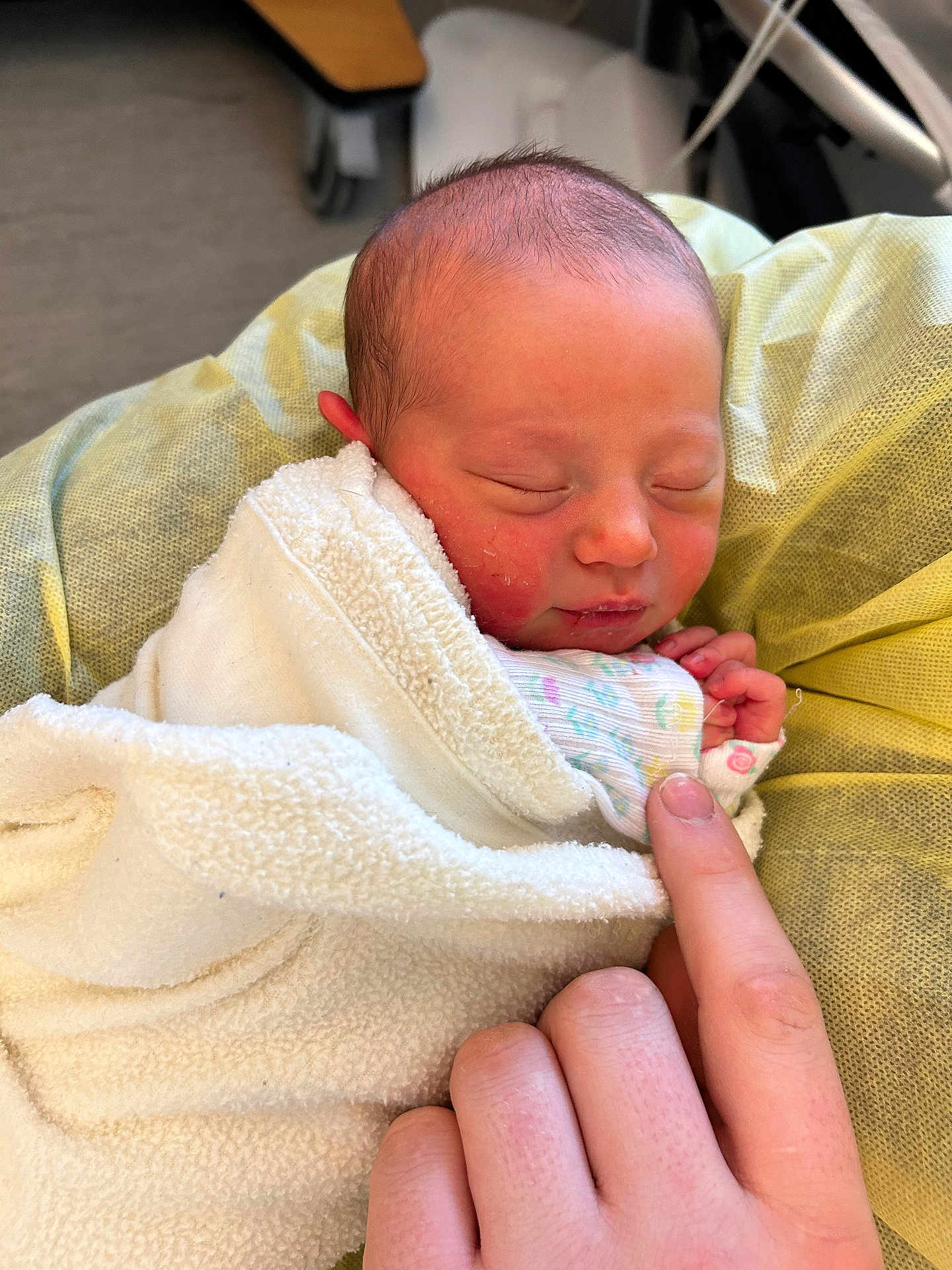 Liliana is registered to the contest to win money with this photo: baby, newborn, infant, sleeping, swaddle, blanket, hospital_bed, hand, finger, portrait, closeup, cute, peaceful, soft_texture, skin, nail, bedding, medical_equipment, resting, parent_touch