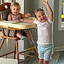 Kenzie is registered to the contest to win money with this photo: child, baby, toddler, high_chair, smile, happy, indoor, wooden_chair, flooring, window, clothing, socks, shorts, tshirt, person, cute, family, home, playful, joyful