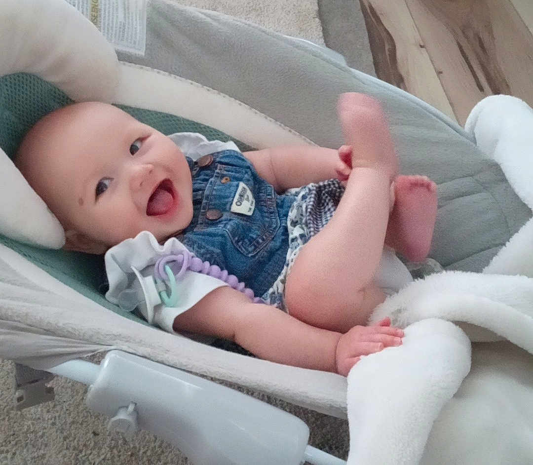 Raelyn joined the competition — help win amazing prizes! baby, infant, smiling, denim, romper, baby_seat, blanket, carpet, happy, cute, child, indoor, playful, legs, hand, clothing, face, person, cozy, home