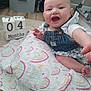 Raelyn is registered to the contest to win money with this photo: baby, infant, smiling, denim_overalls, blanket, rainbow_pattern, months_blocks, crawling, happy, child, floor, carpet, hand, foot, indoor, person, cute, milestone, clothing, portrait