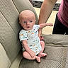 baby, child, car_seat, onesie, person, arm, seat, fabric, texture, indoor, support, infant, clothing, cute, curious, human, skin, foot, hand, casual