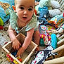 baby, child, toy, wooden_box, plush_toy, stuffed_animal, play_mat, floor, indoor, curious, striped_clothing, octopus_toy, giraffe_toy, colorful, playtime, infant, hand, face, expression, crawling