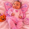 antennae, baby, blanket, butterfly_costume, child, costume, halloween, headband, heart_sign, indoor, infant, onesie, pink, portrait, pumpkin, sitting, slippers, smiling, tutu, wings