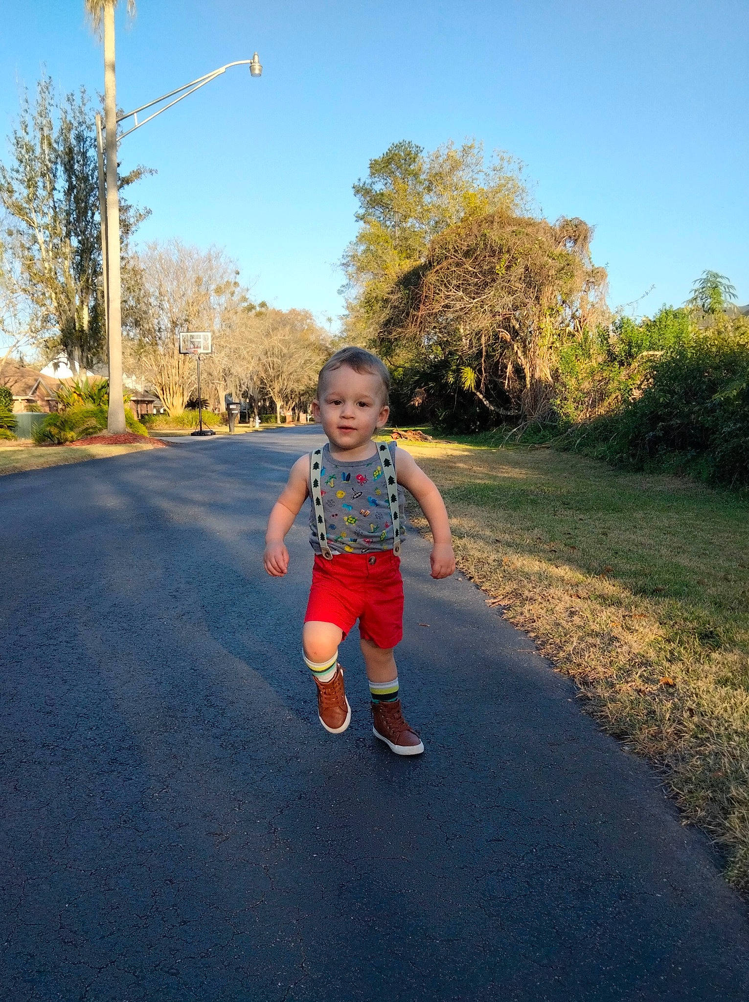 Victor Lucian is registered to the contest to win money with this photo: asphalt, baby, grass, happy, landscape, leisure, people_in_nature, person, plant, road, road_surface, shorts, sky, standing, summer, sunlight, thoroughfare, tints_and_shades, toddler, tree