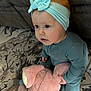 baby, child, pajamas, headband, bow, stuffed_animal, pink_bunny, toy, carpet, rug, couch, indoor, floor, curious, sitting, cute, infant, blue_eyes, soft_toy, home