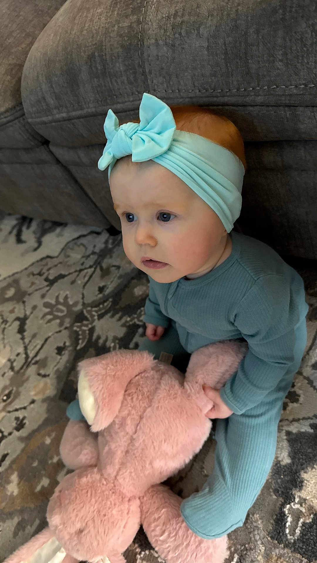 Lilliana joined the competition — help win amazing prizes! baby, child, pajamas, headband, bow, stuffed_animal, pink_bunny, toy, carpet, rug, couch, indoor, floor, curious, sitting, cute, infant, blue_eyes, soft_toy, home
