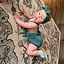 Lilliana is registered to the contest to win money with this photo: baby, child, crawling, headband, romper, green_clothing, patterned_rug, wooden_floor, indoor, curious_expression, sock, toy, home, floor, infant, chubby_cheeks, person, cute, young_child, playtime