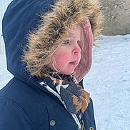 Lina participe au concours pour gagner de l'argent avec cette photo : child, winter_coat, hood, fur_trim, scarf, snow, outdoor, cold_weather, profile, face, rosy_cheeks, young_child, zipper, button, jacket, frosty, frozen, curly_hair, portrait, side_view