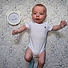baby, infant, onesie, blue_socks, teddy_bear_pattern, blanket, lying_down, age_marker, 3_months, cute, child, portrait, indoors, young, smiling, face, hands_up, feet, baby_clothing, soft_lighting