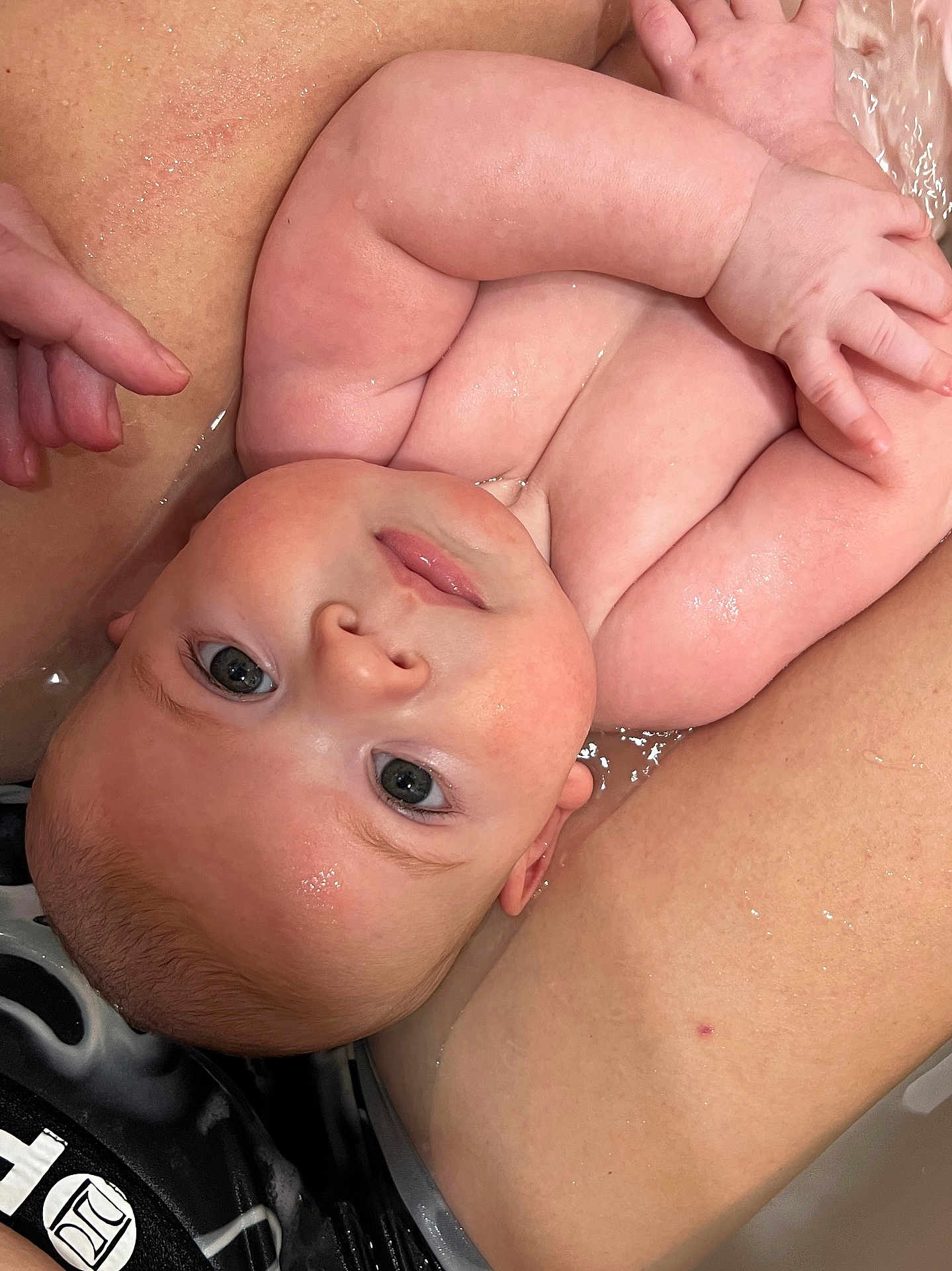 Mason joined the competition — help win amazing prizes! baby, infant, bath, water, skin, arms, closeup, cute, child, face, eyes, wet, newborn, person, human, relaxing, comfort, tub, parent, holding