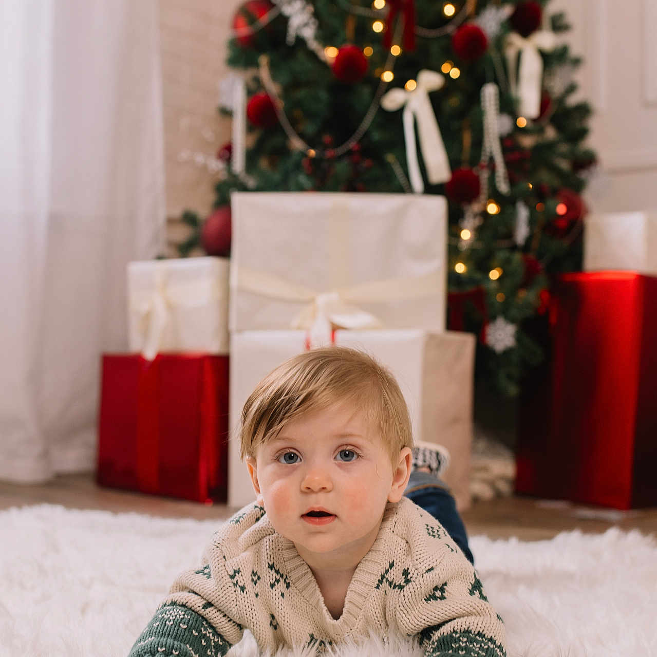 Brixton is registered to the contest to win money with this photo: baby, child, christmas_tree, cozy, cute, decorations, face, festive, floor, holiday, home, indoors, portrait, presents, rug, soft, sweater, toddler, winter_wear, young_child