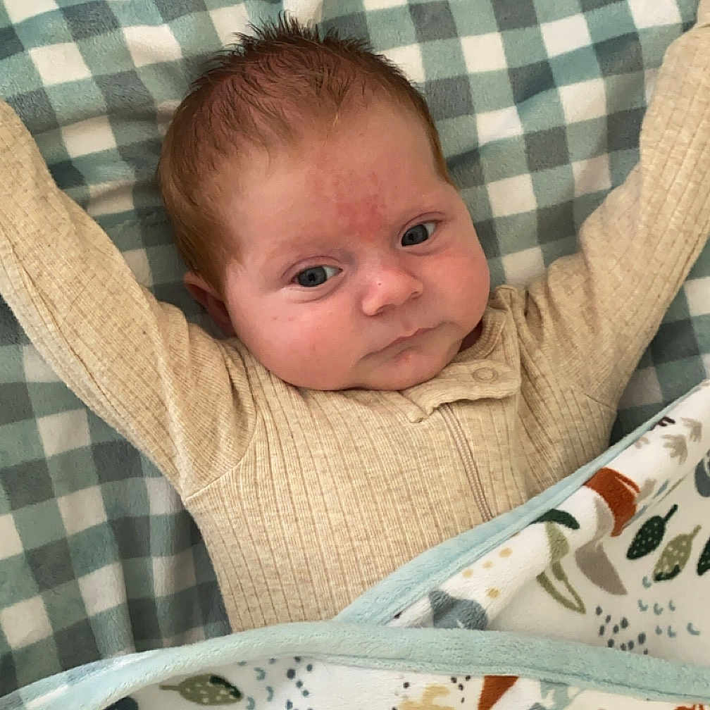 Calum is registered to the contest to win money with this photo: baby, bed, bedroom, blanket, clothing, cushion, face, furniture, head, homedecor, indoors, knitwear, linen, newborn, person, photography, portrait, quilt, room, sweater