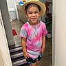 Génesis joined the competition — help win amazing prizes! child, smile, hat, straw_hat, pink_shirt, tie_dye, shorts, floral_shorts, indoor, floor_rug, plant, home_interior, wood_floor, door, closet, toy_monkey, gold_necklace, happy, person, standing