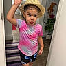Génesis is registered to the contest to win money with this photo: child, hat, tongue_out, colorful_clothing, shorts, tshirt, necklace, earrings, indoor, hallway, rug, plant, doorway, wood_floor, playful, person, smiling, gesture, home, casual