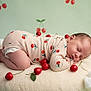baby, sleeping, onesie, cherry_pattern, cushion, fluffy, red_cherries, cotton_clouds, background, infant, peaceful, cute, soft_texture, child, newborn, pose, decor, studio, photography, resting