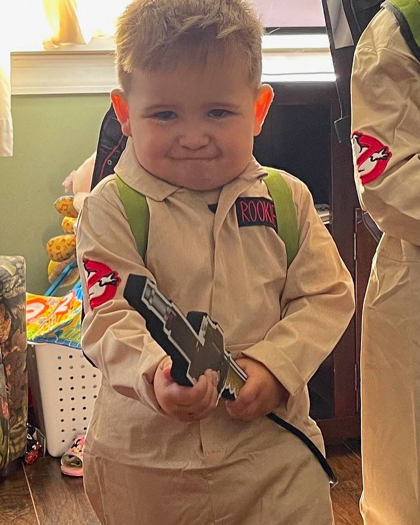 Malakai is registered to the contest to win money with this photo: baby, baby_toddler_clothing, bag, carmine, child, gesture, hairstyle, happy, head, human_body, joy, luggage_and_bags, pattern, person, personal_protective_equipment, sitting, sleeve, smile, t_shirt, thumb