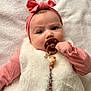 baby, infant, pacifier, headband, pink_clothing, white_vest, soft_texture, blanket, closeup, portrait, child, cute, adorable, indoor, person, face, hand, expression, laying, young