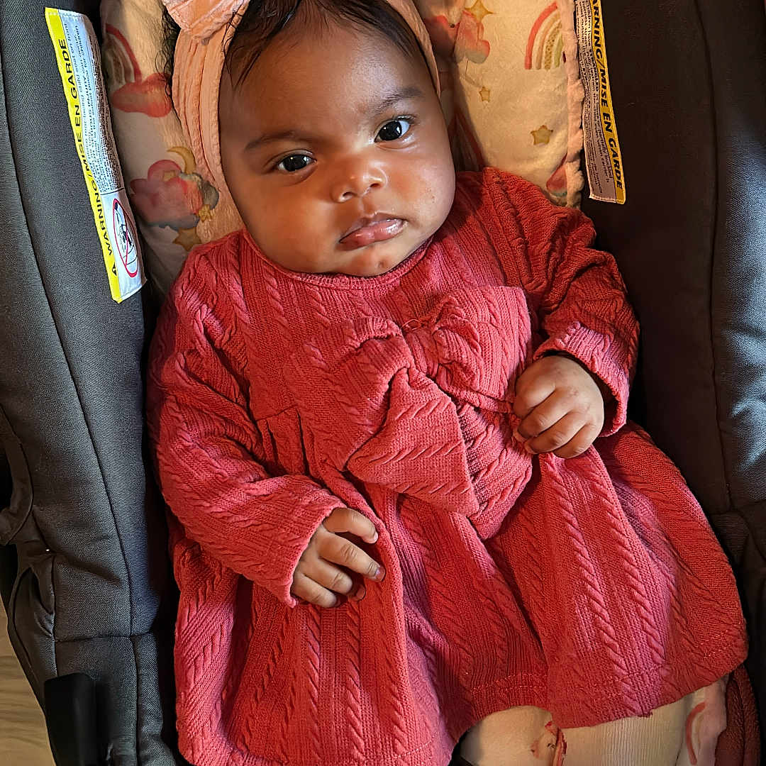 Meret joined the competition — help win amazing prizes! baby, bunny_design, car_seat, child, clothing, cushion, cute, face, floor, footwear, hand, headband, indoors, infant, patterned_clothing, pink_dress, portrait, sandals, seated, tights