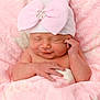 newborn, baby, pink_blanket, hat, bow, sleeping, infant, cute, soft_texture, wrapped, peaceful, adorable, portrait, skin, hand, face, resting, cozy, child, warm