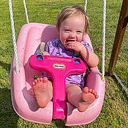 Hayley joined the competition — help win amazing prizes! toddler, child, swing, outdoor, grass, sunny, smiling, purple_clothing, unicorn_pattern, barefoot, playground, happy, daytime, nature, tree, rope, seat, person, baby, fun
