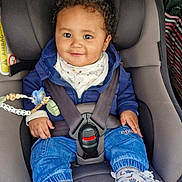 Tidiane participe au concours pour gagner de l'argent avec cette photo : baby, child, car_seat, seat_belt, smile, curly_hair, pacifier, beaded_toy, jeans, sneakers, jacket, bib, buckle, safety, car_interior, happy, portrait, infant, cute, toddler