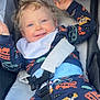 Cohen joined the competition — help win amazing prizes! toddler, child, stroller, curly_hair, blue_eyes, smiling, bib, colorful_clothing, vehicles_pattern, seatbelt, happy, baby, infant, outdoor, casual_wear, playful, safety_harness, cute, portrait, young_child