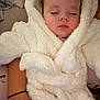 baby, sleeping, fluffy_robe, white_clothing, peaceful, child, infant, soft_texture, close_up, portrait, resting, comfort, warm, cuddly, indoor, person, arm, skin, cozy, relaxed