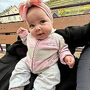 Leya participe au concours pour gagner de l'argent avec cette photo : baby, child, infant, smile, headband, pink_clothing, socks, jacket, pants, bench, outdoor, nature, hill, house, person, hand, portrait, cute, happy, casual
