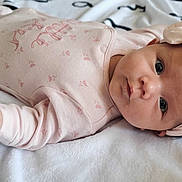 Anh Lise participe au concours pour gagner de l'argent avec cette photo : baby, infant, pink_onesie, headband, bow, blanket, lying_down, soft_texture, cute, portrait, child, newborn, sleepwear, face, skin, hair, hand, indoors, resting, expression