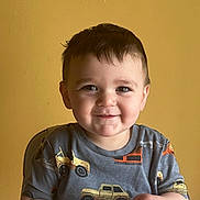 Joseph Anthony is registered to the contest to win money with this photo: child, toddler, smile, happy, face, boy, short_hair, indoor, yellow_wall, shirt, clothing, toy_trucks, sitting, high_chair, snack, hands, cute, portrait, casual, person