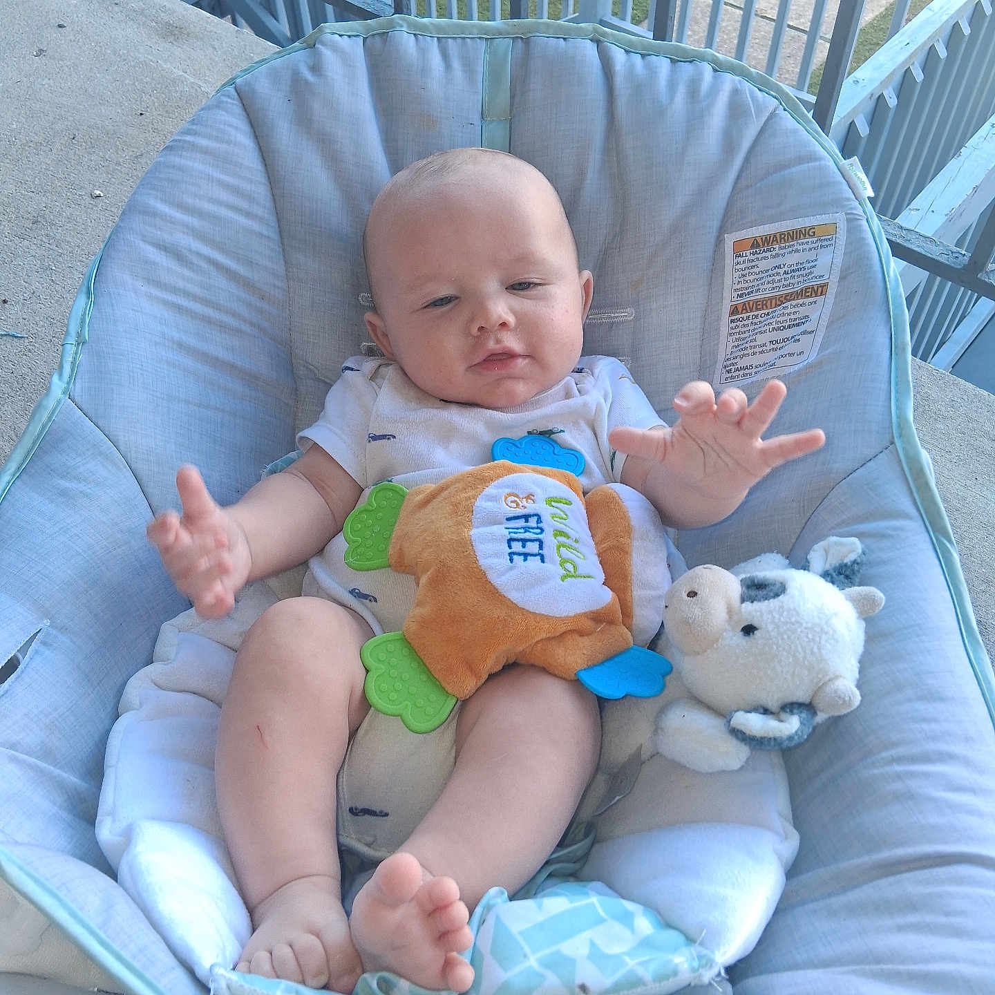 Matthew joined the competition — help win amazing prizes! baby, infant, child, bouncer, seated, outdoor, porch, deck, railing, plush_toy, stuffed_animal, toy, blanket, white_clothing, bare_feet, smiling, face, portrait, backyard, daylight