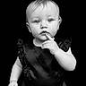 Sarah joined the competition — help win amazing prizes! baby, toddler, child, black_background, portrait, monochrome, curious, thinking, one_person, studio_photo, short_hair, sleeveless, cute, expression, looking_at_camera, isolated, minimalist, young_child, indoor, fashion
