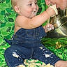 baby, child, adult, cake, denim_overalls, celebration, messy, feeding, smiling, face, hand, foot, green_background, birthday, food, fun, happy, indoor, person, playful