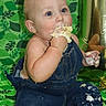 baby, child, denim_overalls, cake, messy, frosting, hands, face, blue_eyes, green_background, balloon, celebration, sitting, cute, indoor, portrait, food, smile, fun, photography
