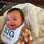 Kyle joined the competition — help win amazing prizes! baby, smiling, bib, blanket, checkered_clothing, infant, happy, cute, face, child, indoor, soft_texture, cozy, person, portrait, head, mouth_open, small_child, cheerful, toddler